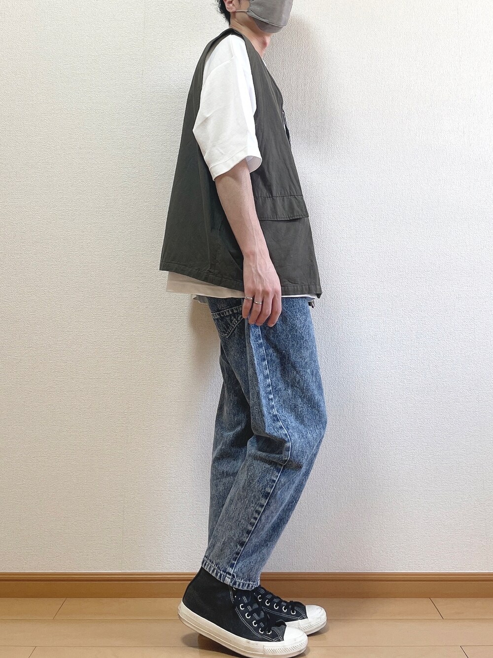 グレー系のベスト、ホワイト系のTシャツ/カットソー、ブルー系のデニムパンツを着用したメンズの夏コーディネートの2枚目の写真