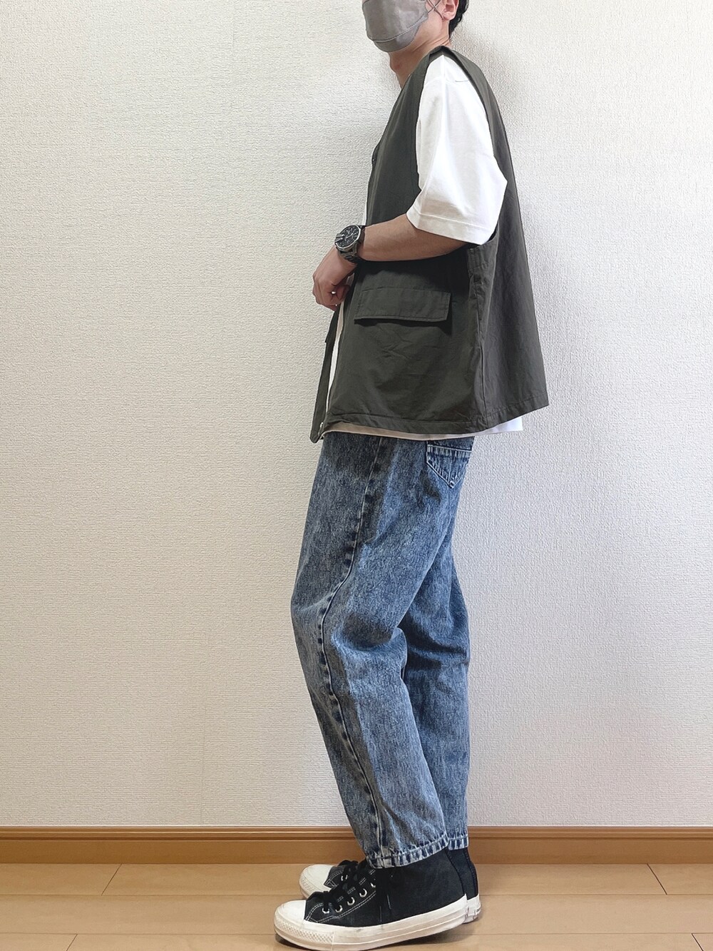 グレー系のベスト、ホワイト系のTシャツ/カットソー、ブルー系のデニムパンツを着用したメンズの夏コーディネートの3枚目の写真