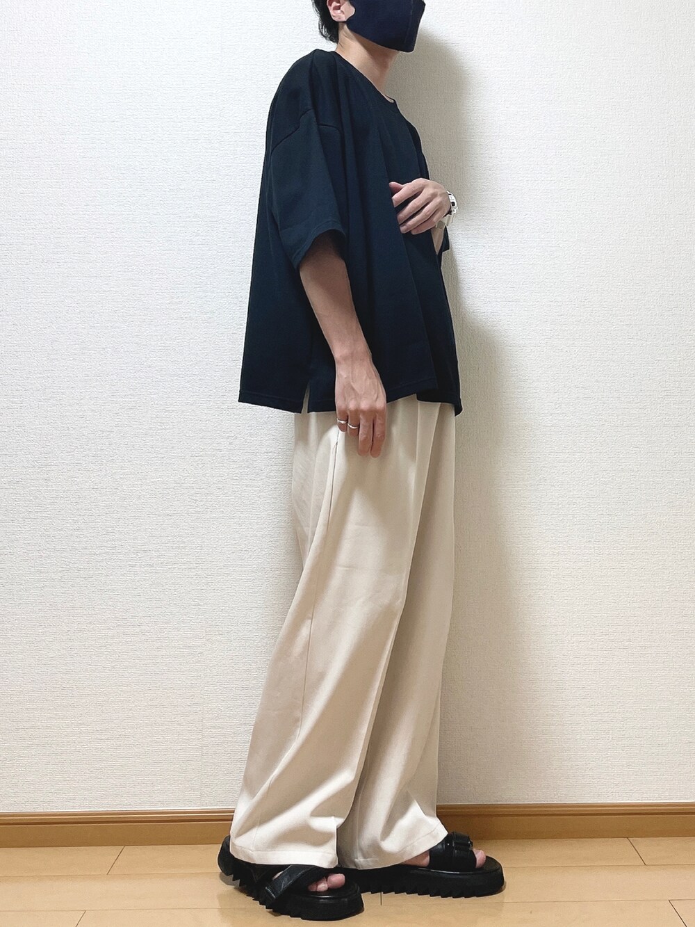 ブラック系のTシャツ/カットソー、ベージュ系のスラックス、ブラック系のサンダルを着用したメンズの夏コーディネートの2枚目の写真