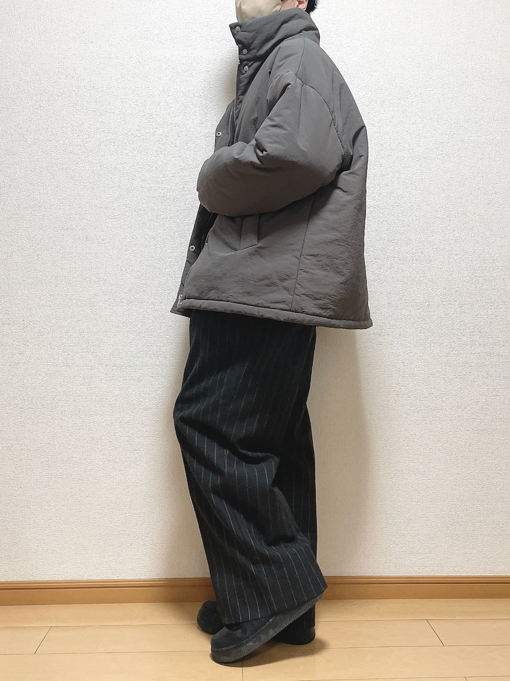 ブラウン系のその他アウター、ブラック系のニット/セーター、ブラック系のパンツを着用したメンズの冬コーディネートの2枚目の写真