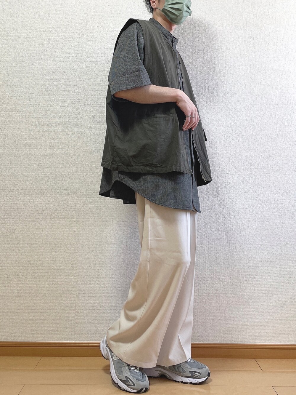 ブラック系のシャツ/ブラウス、グレー系のベスト、ベージュ系のスラックスを着用したメンズの春コーディネートの2枚目の写真