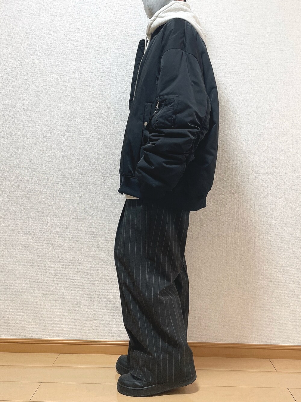 ブラック系のMA-1、グレー系のパーカー、ブラック系のTシャツ/カットソーを着用したメンズの冬コーディネートの3枚目の写真