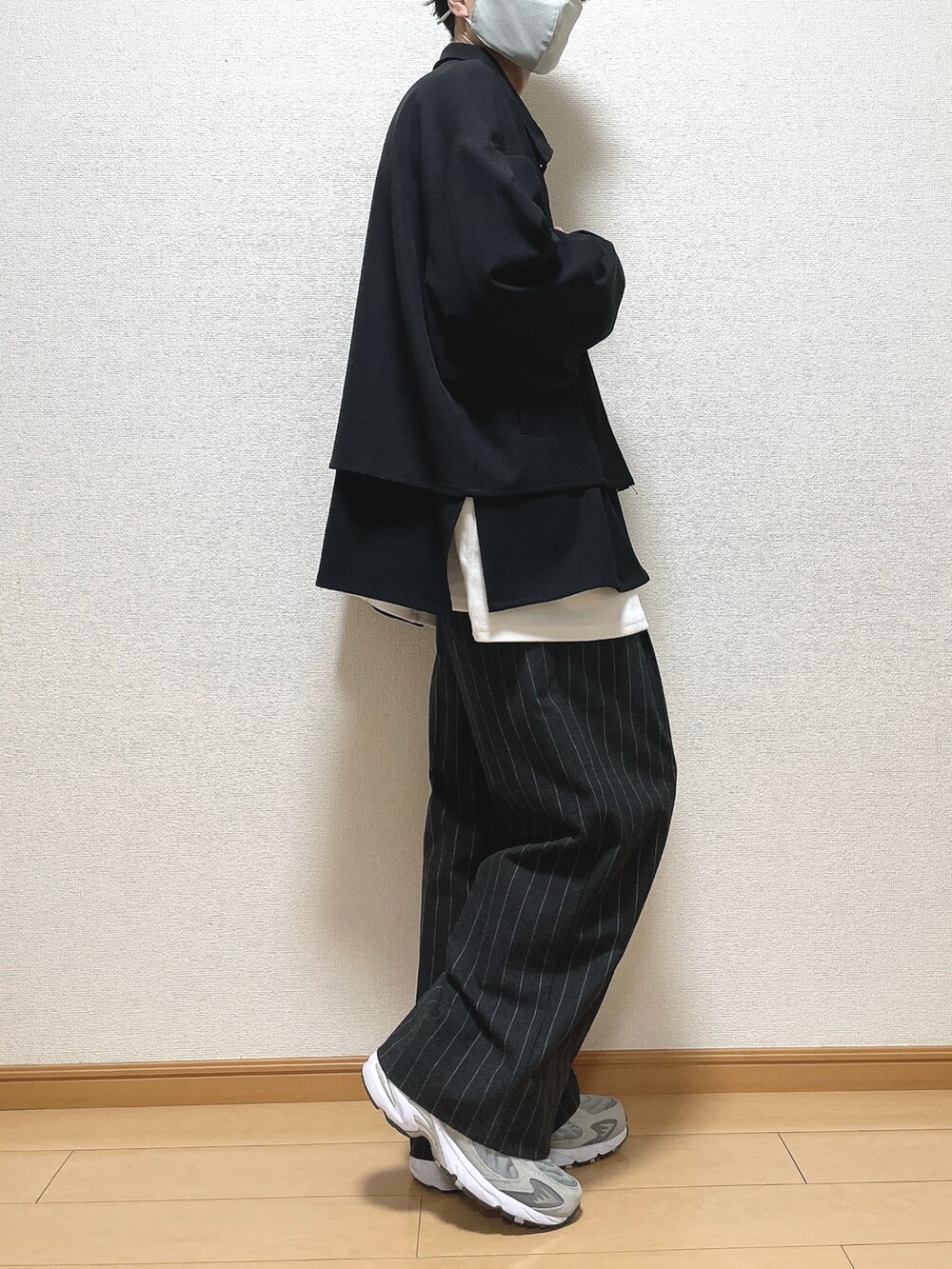 ブラック系のブルゾン、ホワイト系のTシャツ/カットソー、ブラック系のパンツを着用したメンズの秋コーディネートの2枚目の写真