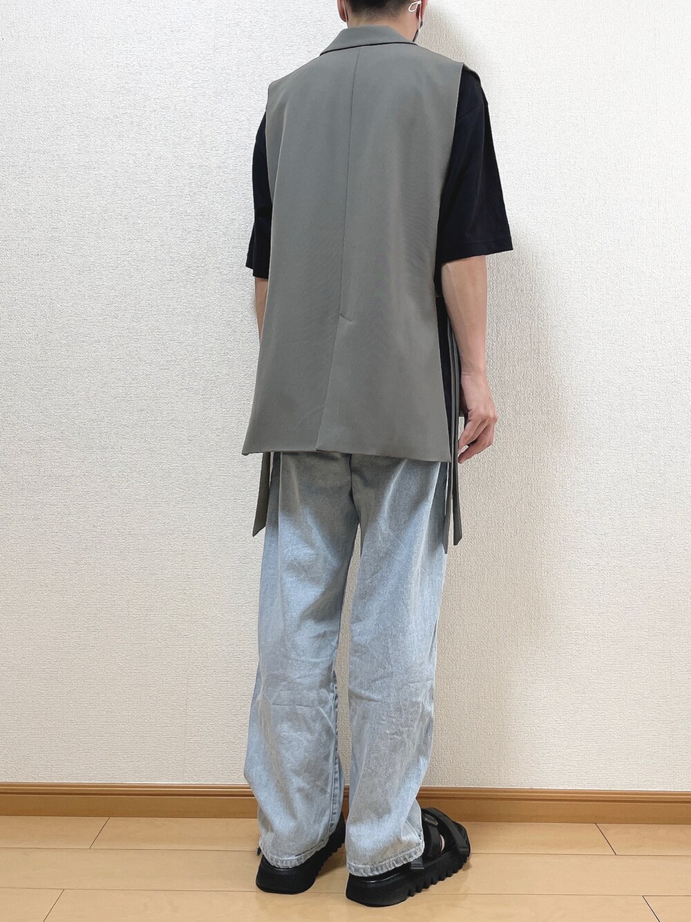 グレー系のベスト、ブラック系のTシャツ/カットソー、ブルー系のデニムパンツを着用したメンズの夏コーディネートの4枚目の写真