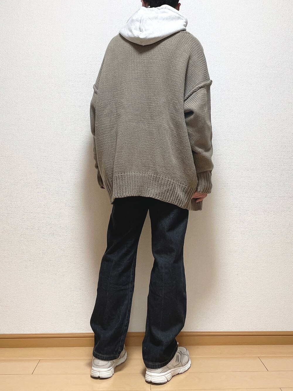 ベージュ系のカーディガン/ボレロ、グレー系のパーカー、ブラック系のデニムパンツを着用したメンズの冬コーディネートの4枚目の写真