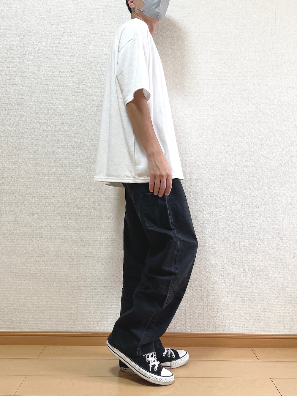 ホワイト系のTシャツ/カットソー、ブラック系のデニムパンツ、ブラック系のスニーカーを着用したメンズの秋コーディネートの2枚目の写真