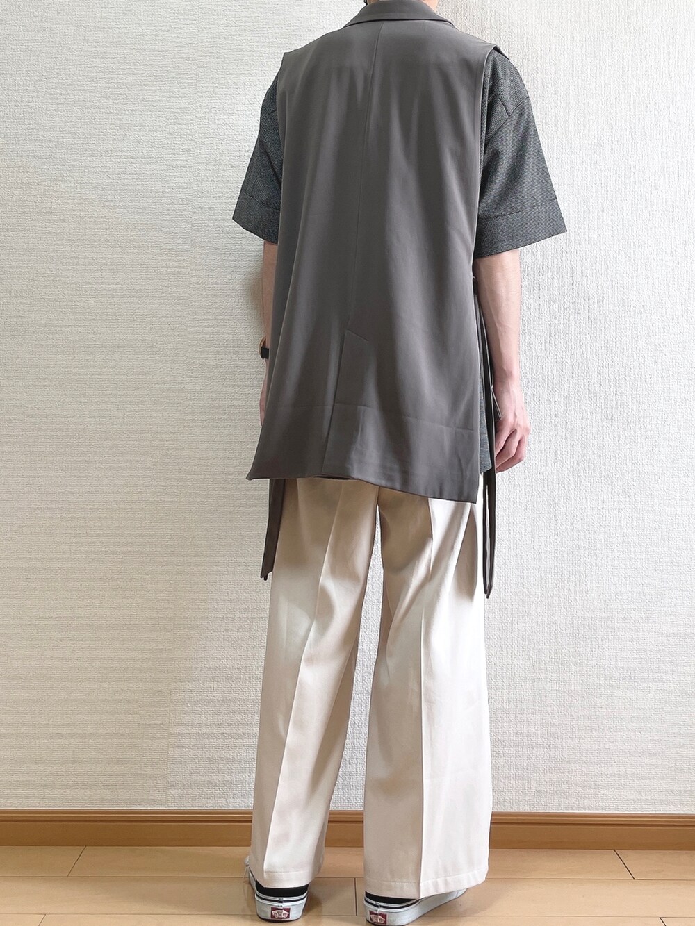 ブラウン系のベスト、ブラック系のシャツ/ブラウス、ベージュ系のスラックスを着用したメンズの夏コーディネートの4枚目の写真