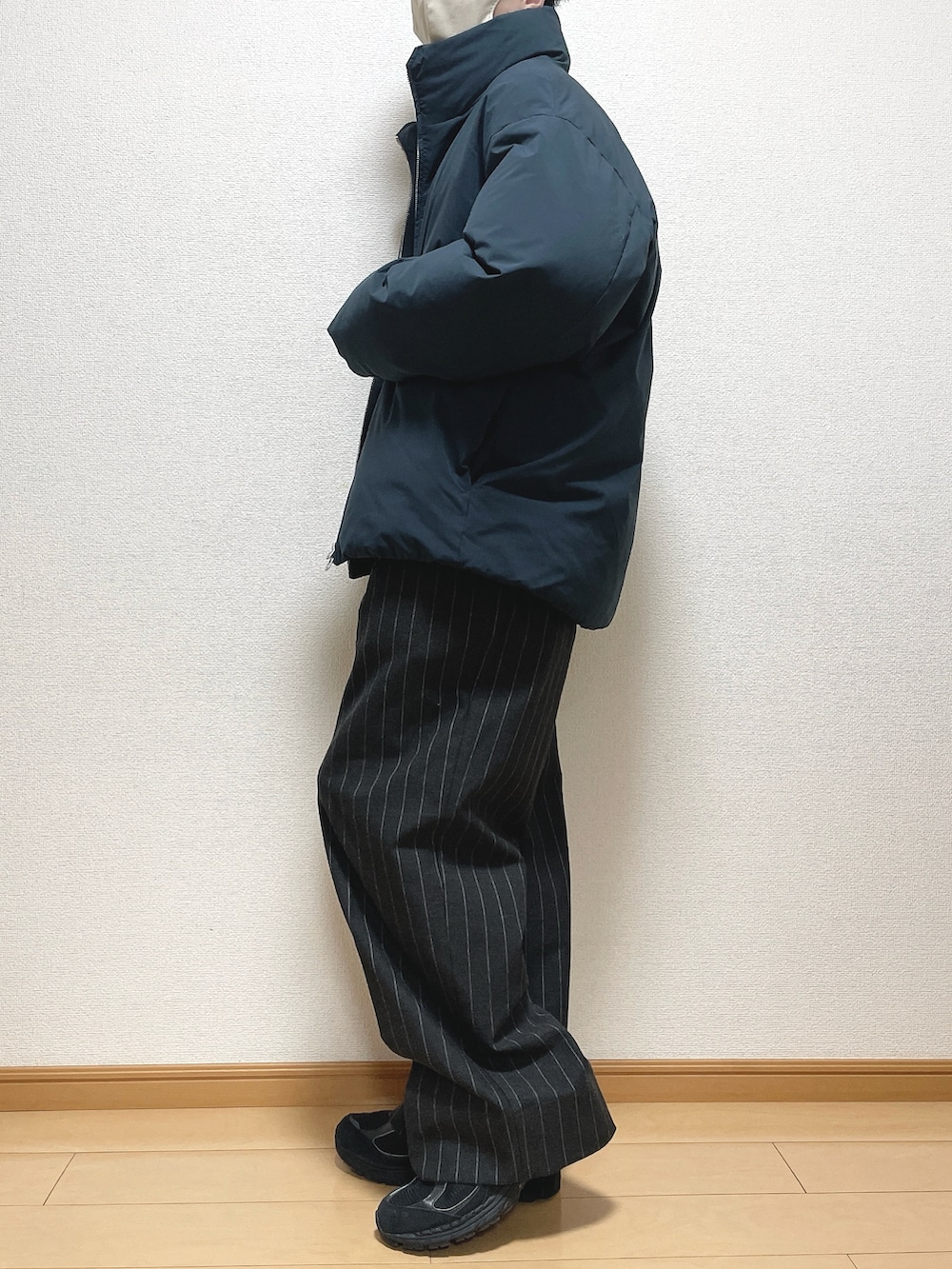 グレー系のダウンジャケット/コート、ベージュ系のニット/セーター、ブラック系のパンツを着用したメンズの冬コーディネートの3枚目の写真