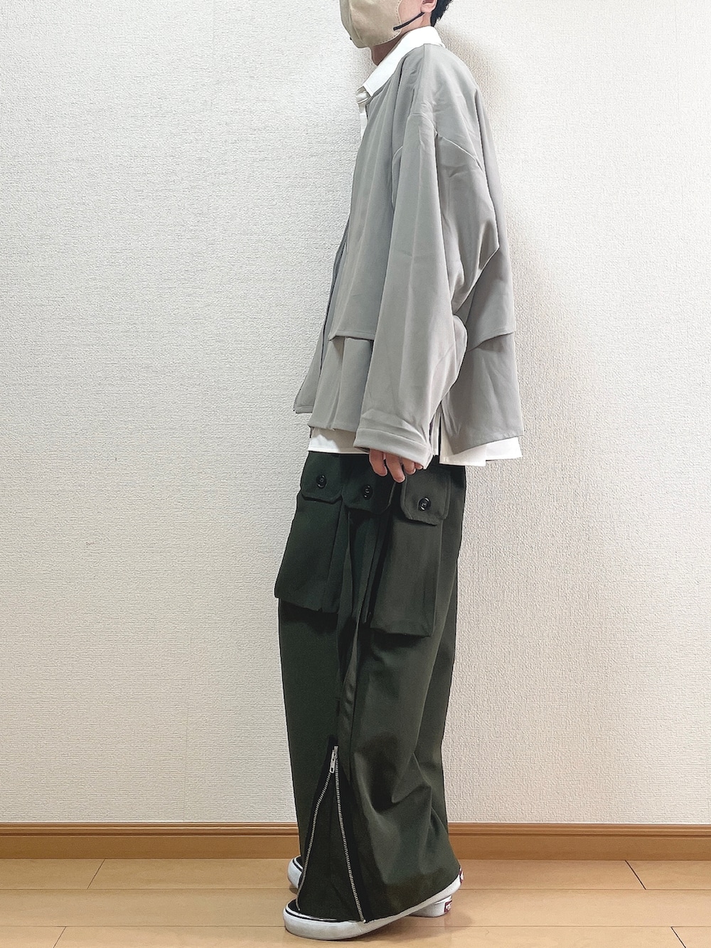 グレー系のブルゾン、ホワイト系のシャツ/ブラウス、グリーン系のカーゴパンツを着用したメンズの春コーディネートの3枚目の写真