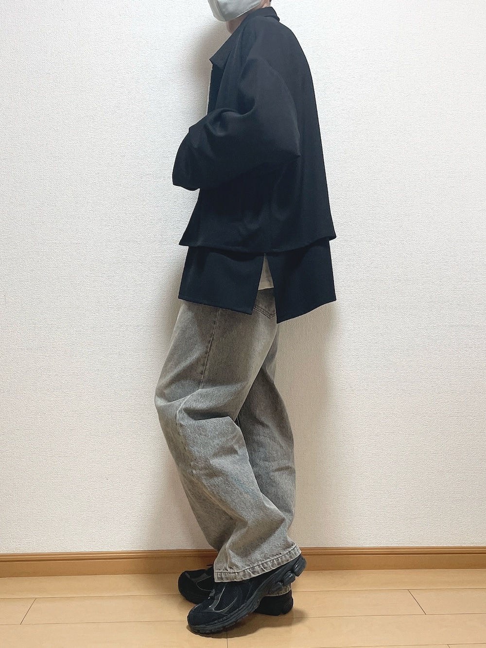 ブラック系のブルゾン、ホワイト系のTシャツ/カットソー、ブルー系のデニムパンツを着用したメンズの春コーディネートの3枚目の写真