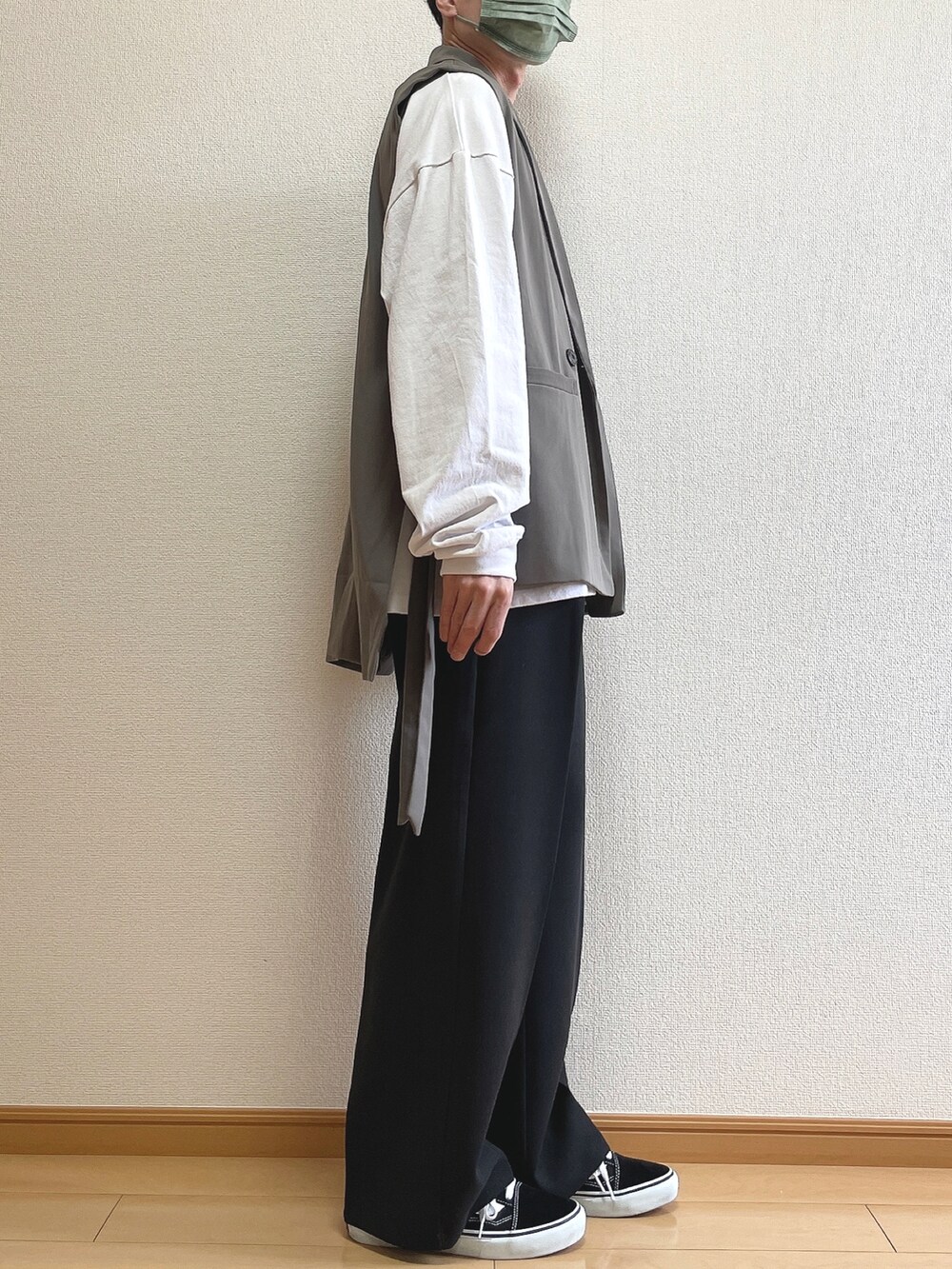 ブラウン系のベスト、ホワイト系のTシャツ/カットソー、ブラック系のその他パンツを着用したメンズの春コーディネートの2枚目の写真