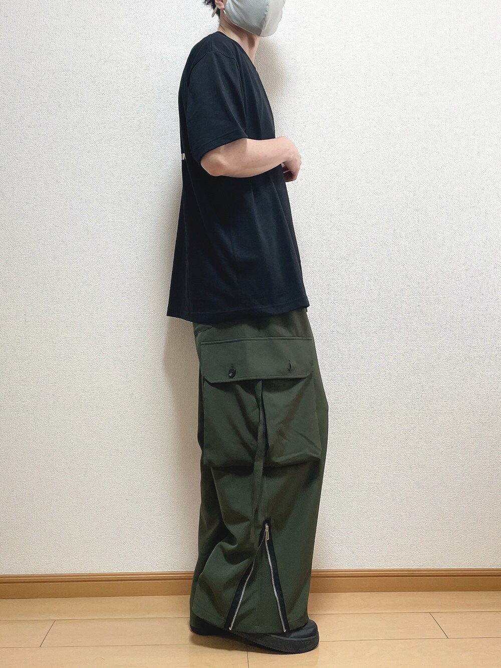 ブラック系のTシャツ/カットソー、グリーン系のカーゴパンツ、ブラック系のスニーカーを着用したメンズの春コーディネートの2枚目の写真