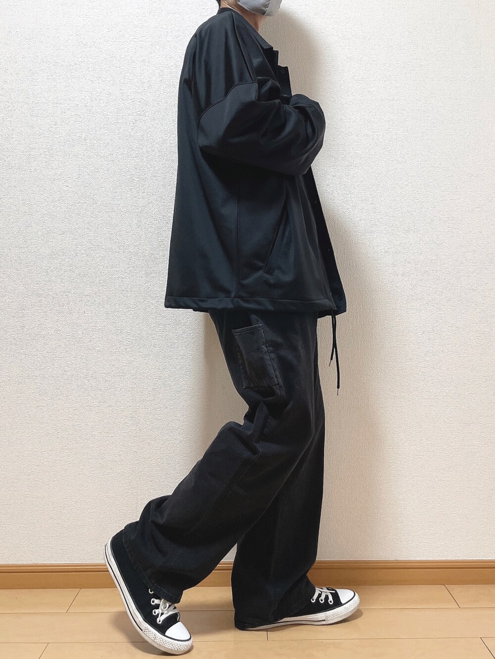 ブラック系のブルゾン、ブルー系のTシャツ/カットソー、ブラック系のデニムパンツを着用したメンズの秋コーディネートの2枚目の写真