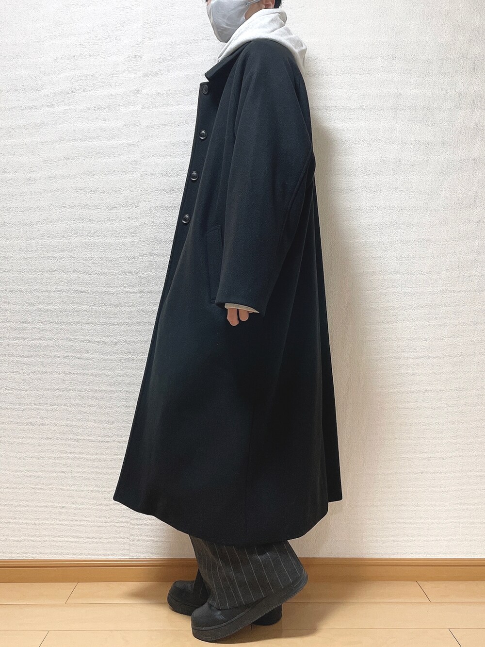 ブラック系のステンカラーコート、グレー系のパーカー、ブラック系のTシャツ/カットソーを着用したメンズの秋コーディネートの3枚目の写真