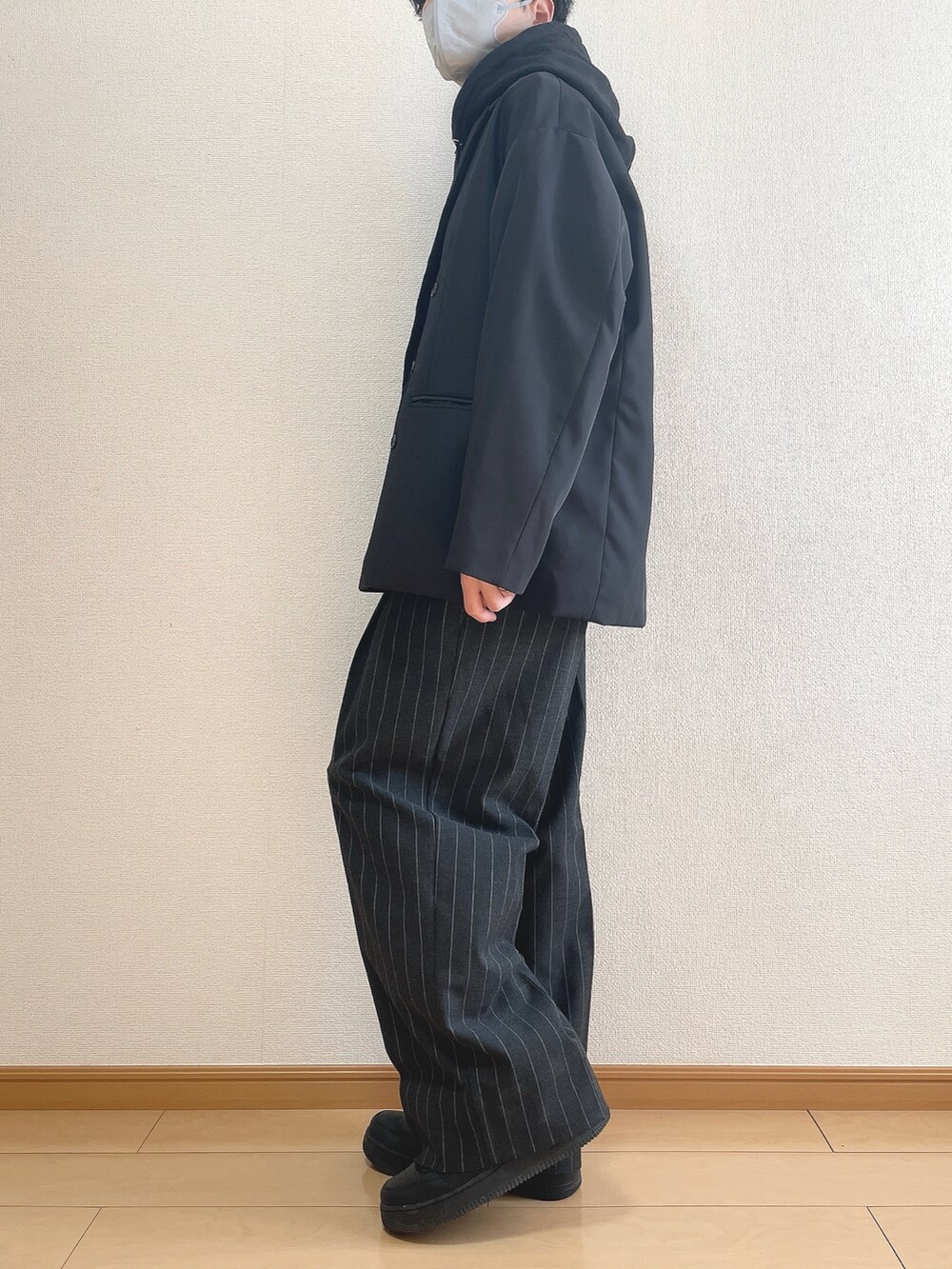 ブラック系のテーラードジャケット、ブラック系のパーカー、ブラック系のパンツを着用したメンズの冬コーディネートの3枚目の写真