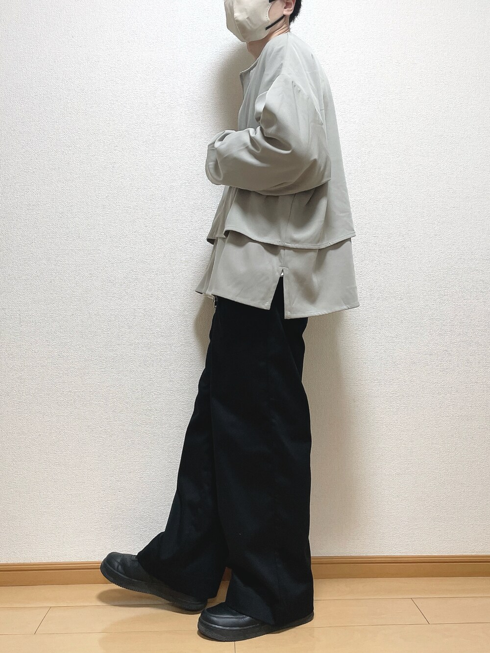 グレー系のブルゾン、ホワイト系のTシャツ/カットソー、ブラック系のスラックスを着用したメンズの春コーディネートの3枚目の写真