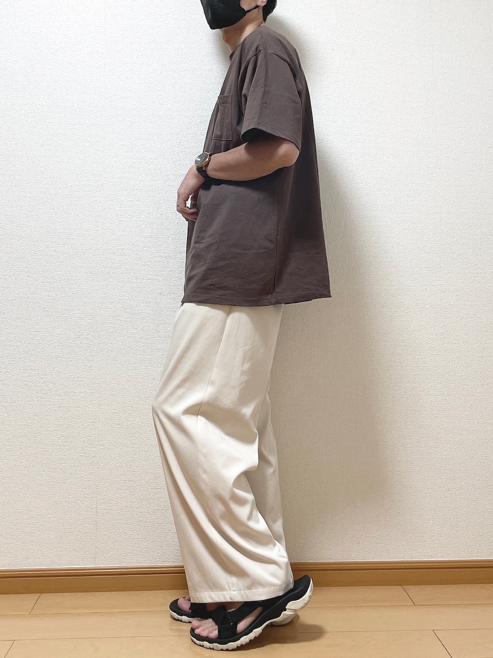 ブラウン系のTシャツ/カットソー、ベージュ系のスラックス、ブラック系のサンダルを着用したメンズの夏コーディネートの3枚目の写真