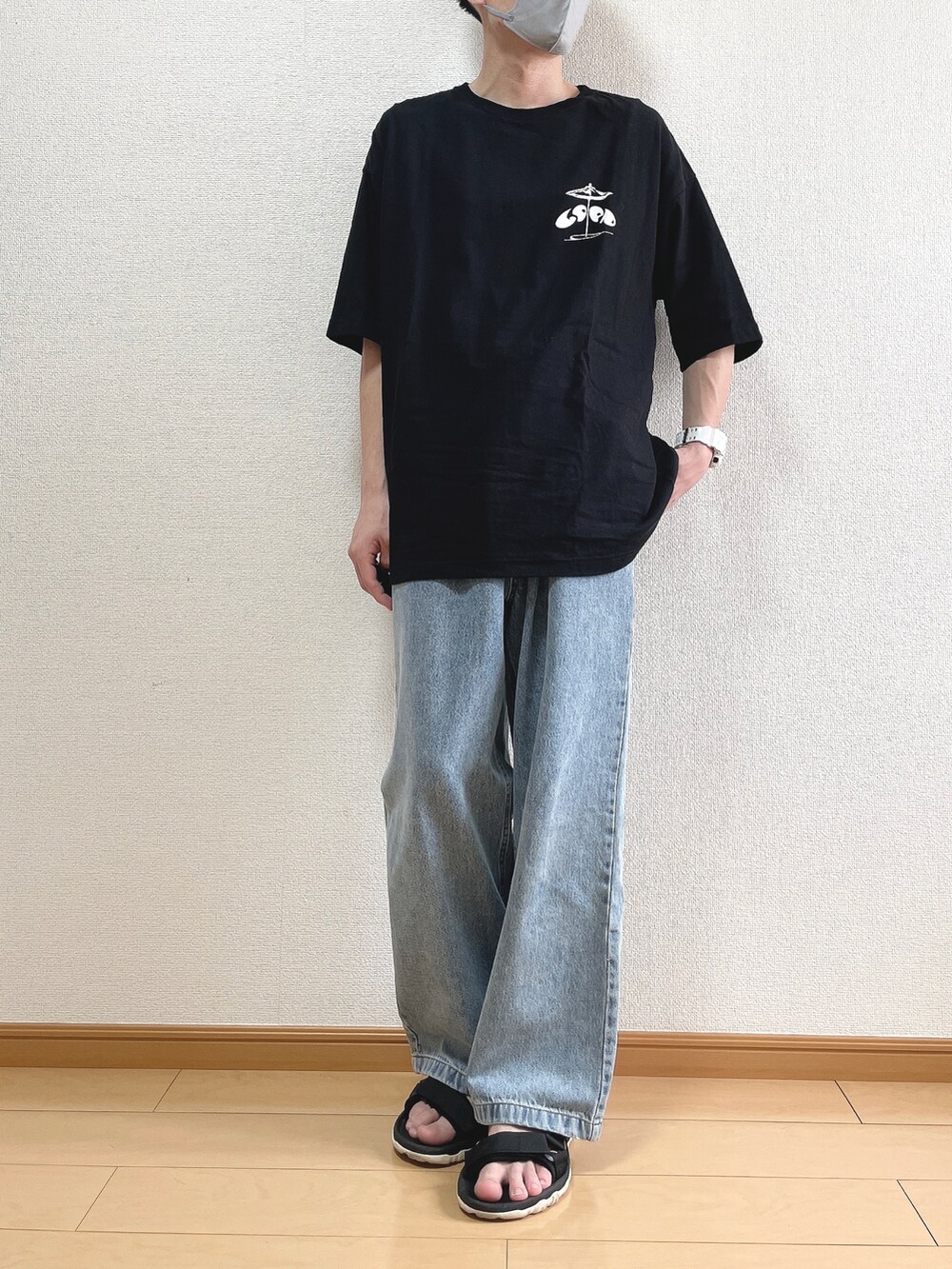 ブラック系のTシャツ/カットソー、ブルー系のデニムパンツ、ブラック系のサンダルを着用したメンズの夏コーディネートの2枚目の写真
