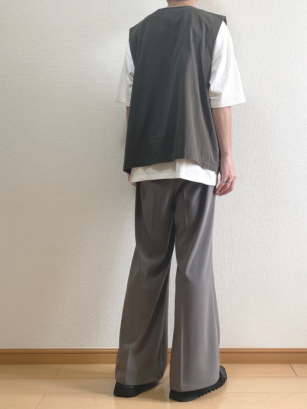 グレー系のベスト、ホワイト系のTシャツ/カットソー、ブラウン系のスラックスを着用したメンズの夏コーディネートの4枚目の写真