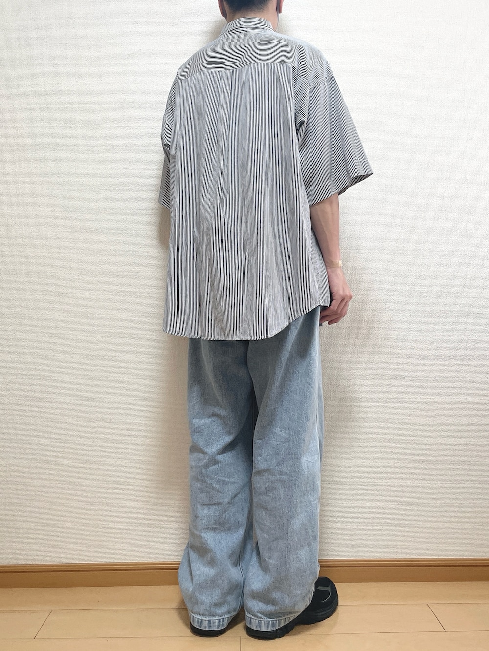 ブラック系のスニーカー、ブルー系のシャツ/ブラウス、ブルー系のデニムパンツを着用したメンズの秋コーディネートの4枚目の写真