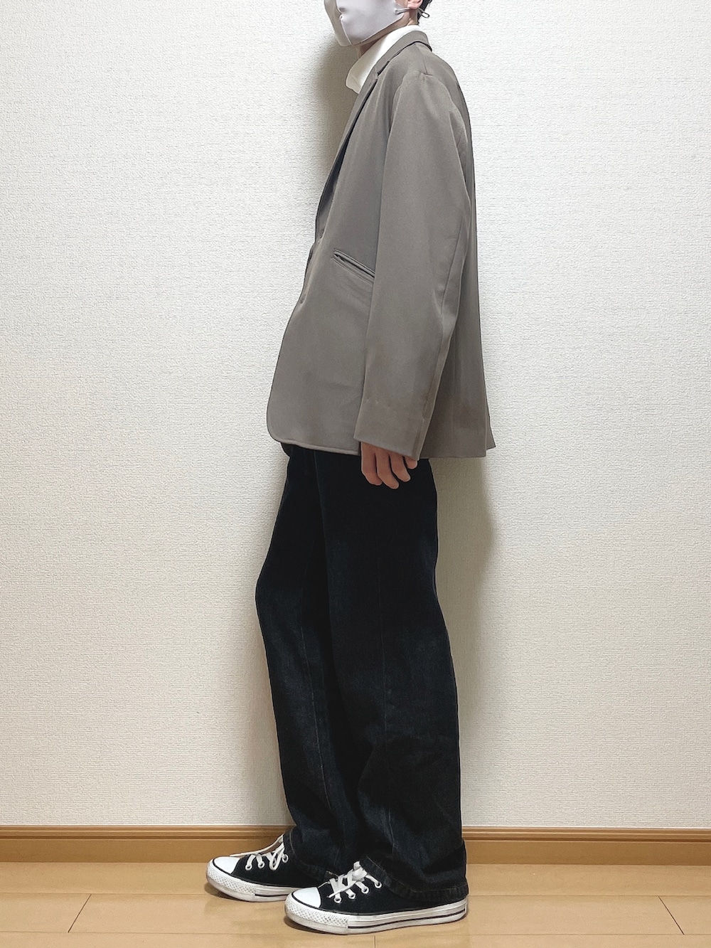 ベージュ系のセットアップ、ホワイト系のTシャツ/カットソー、ブラック系のデニムパンツを着用したメンズの春コーディネートの3枚目の写真