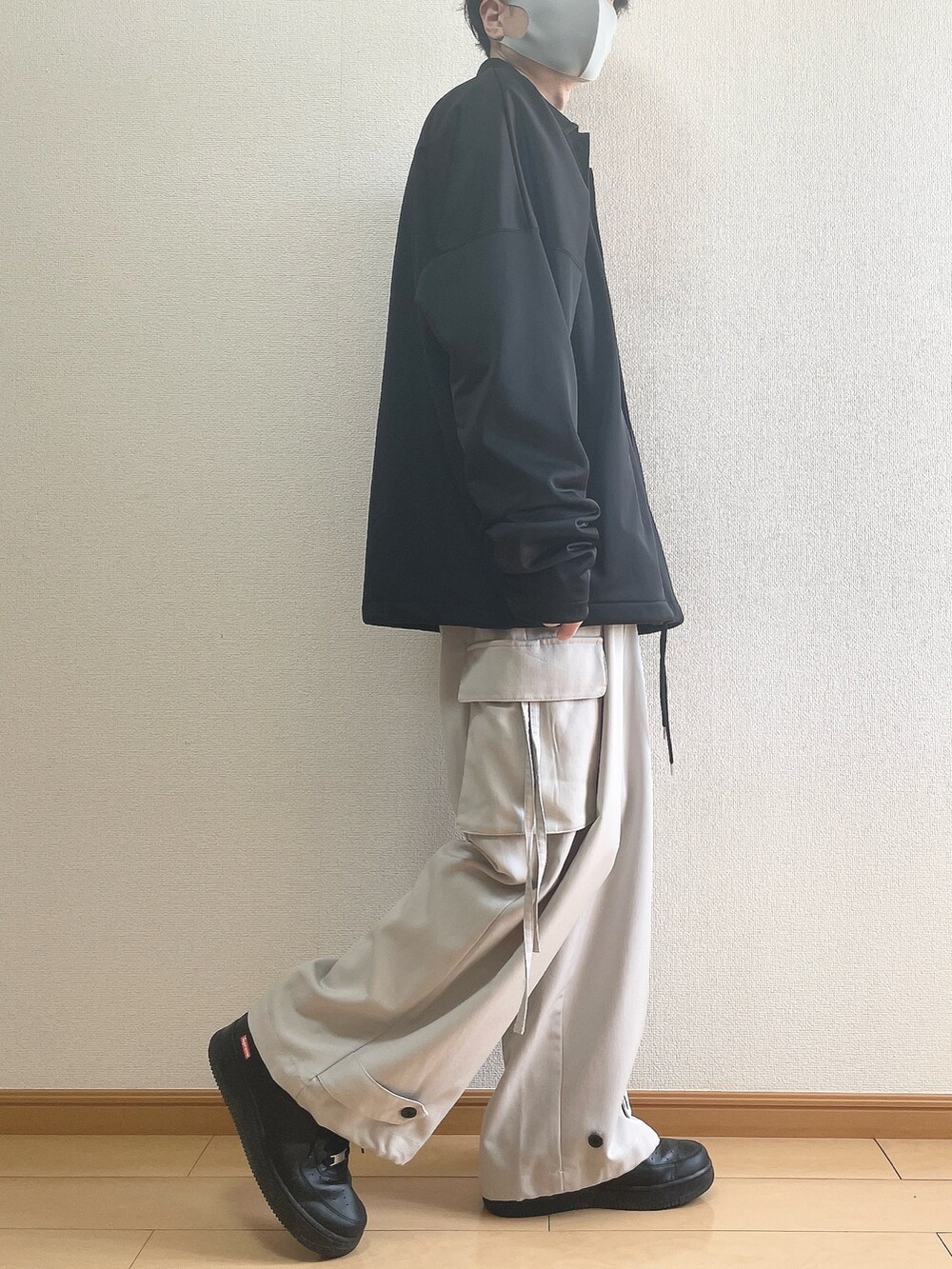 ブラック系のブルゾン、ブラック系のスウェット、グレー系のカーゴパンツを着用したメンズの春コーディネートの2枚目の写真