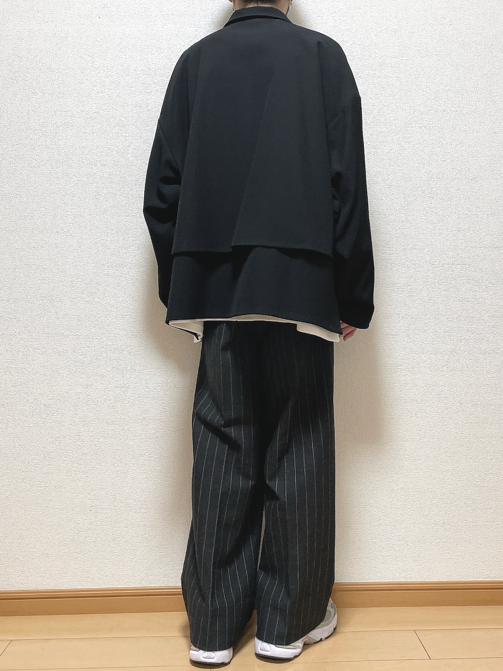 ブラック系のブルゾン、ホワイト系のTシャツ/カットソー、ブラック系のパンツを着用したメンズの秋コーディネートの4枚目の写真