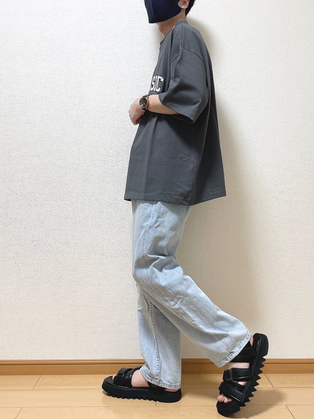 グレー系のTシャツ/カットソー、ブルー系のデニムパンツ、ブラック系のサンダルを着用したメンズの夏コーディネートの3枚目の写真