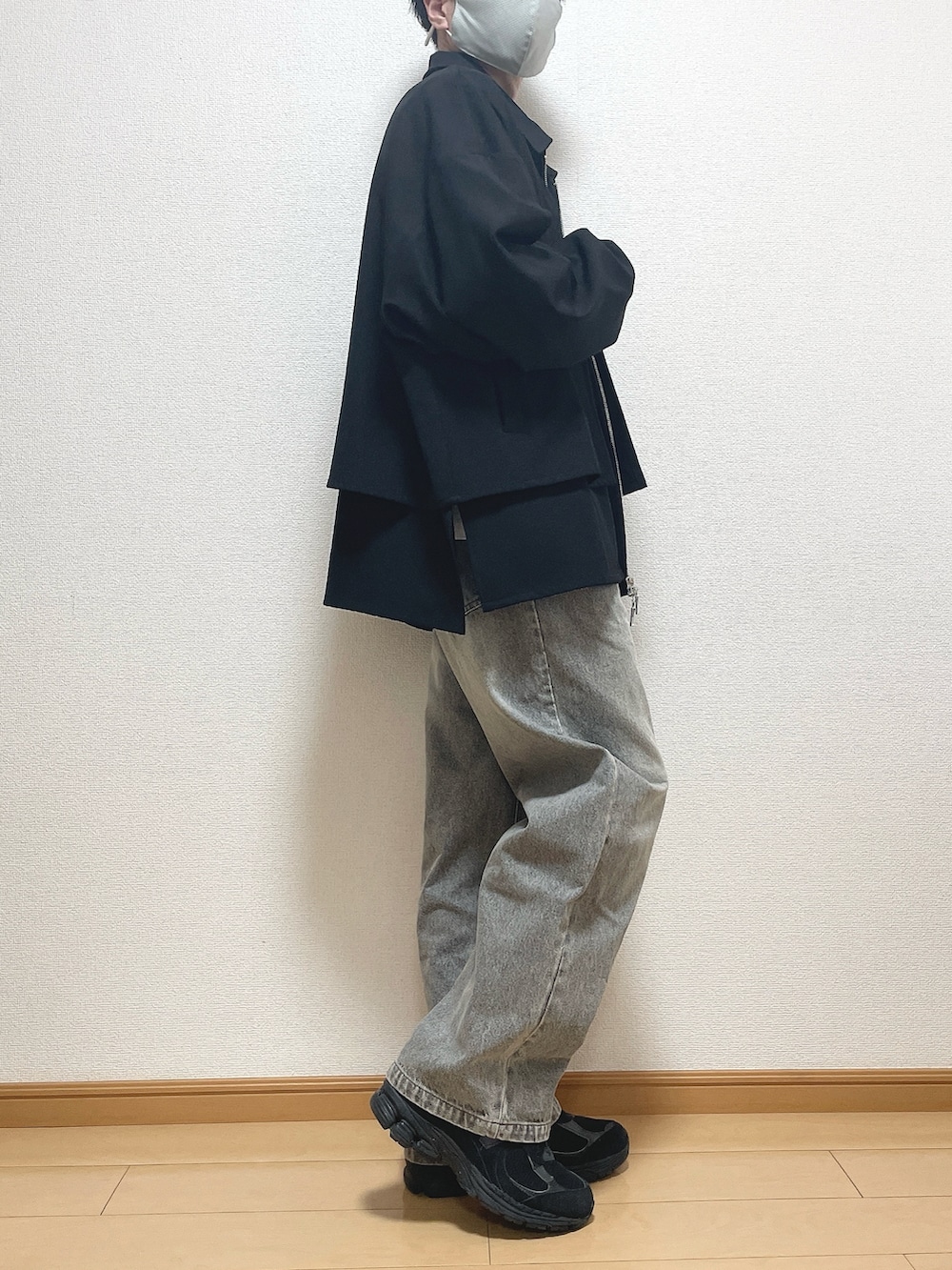 ブラック系のブルゾン、ホワイト系のTシャツ/カットソー、ブルー系のデニムパンツを着用したメンズの春コーディネートの2枚目の写真