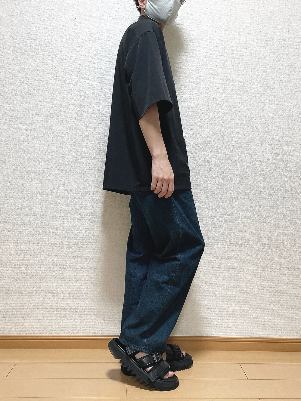 ホワイト系のTシャツ/カットソー、ブルー系のデニムパンツ、ブラック系のサンダルを着用したメンズの夏コーディネートの2枚目の写真