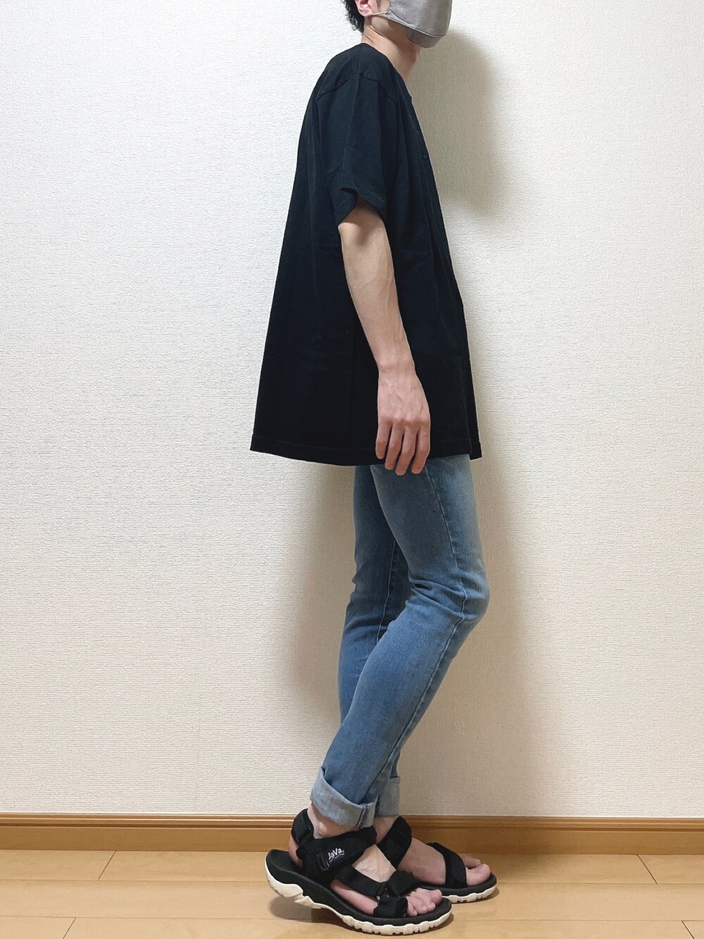 ブラック系のTシャツ/カットソー、ブルー系のデニムパンツ、ブラック系のサンダルを着用したメンズの夏コーディネートの2枚目の写真