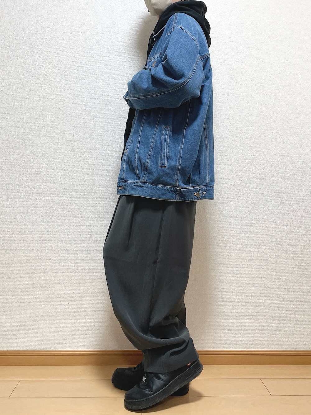 ブラック系のパーカー、グレー系のスラックス、ブラック系のスニーカーを着用したメンズの春コーディネートの3枚目の写真