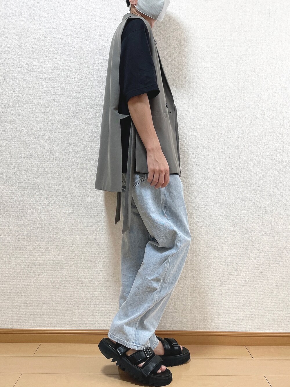 グレー系のベスト、ブラック系のTシャツ/カットソー、ブルー系のデニムパンツを着用したメンズの夏コーディネートの2枚目の写真