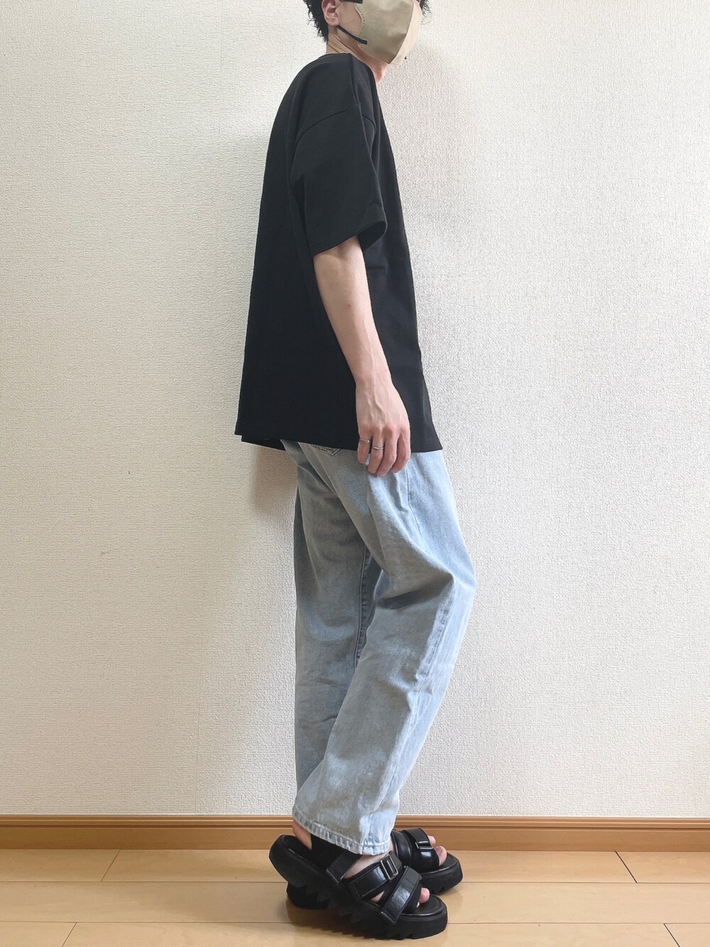 ブラック系のTシャツ/カットソー、ブルー系のデニムパンツ、ブラック系のサンダルを着用したメンズの春コーディネートの2枚目の写真