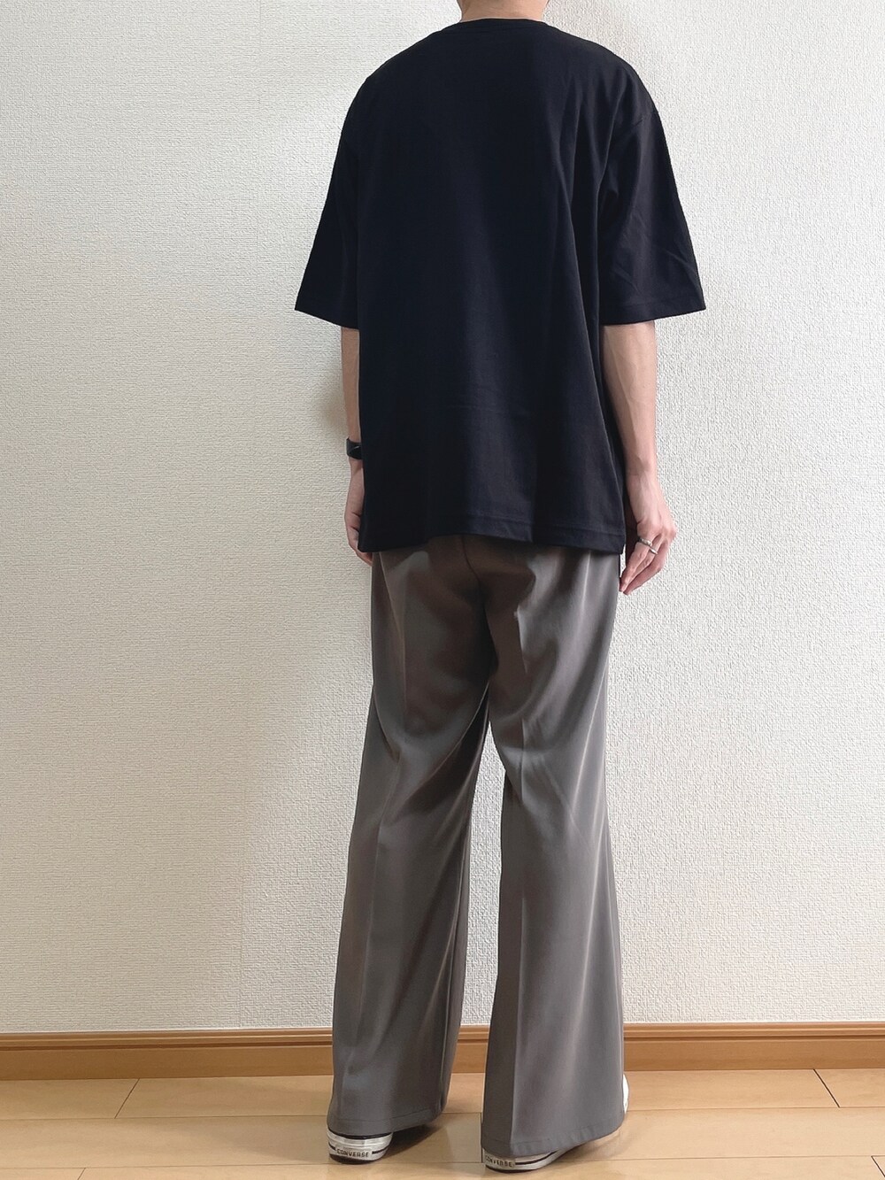 ブラック系のTシャツ/カットソー、ブラウン系のスラックス、ブラック系のスニーカーを着用したメンズの夏コーディネートの4枚目の写真