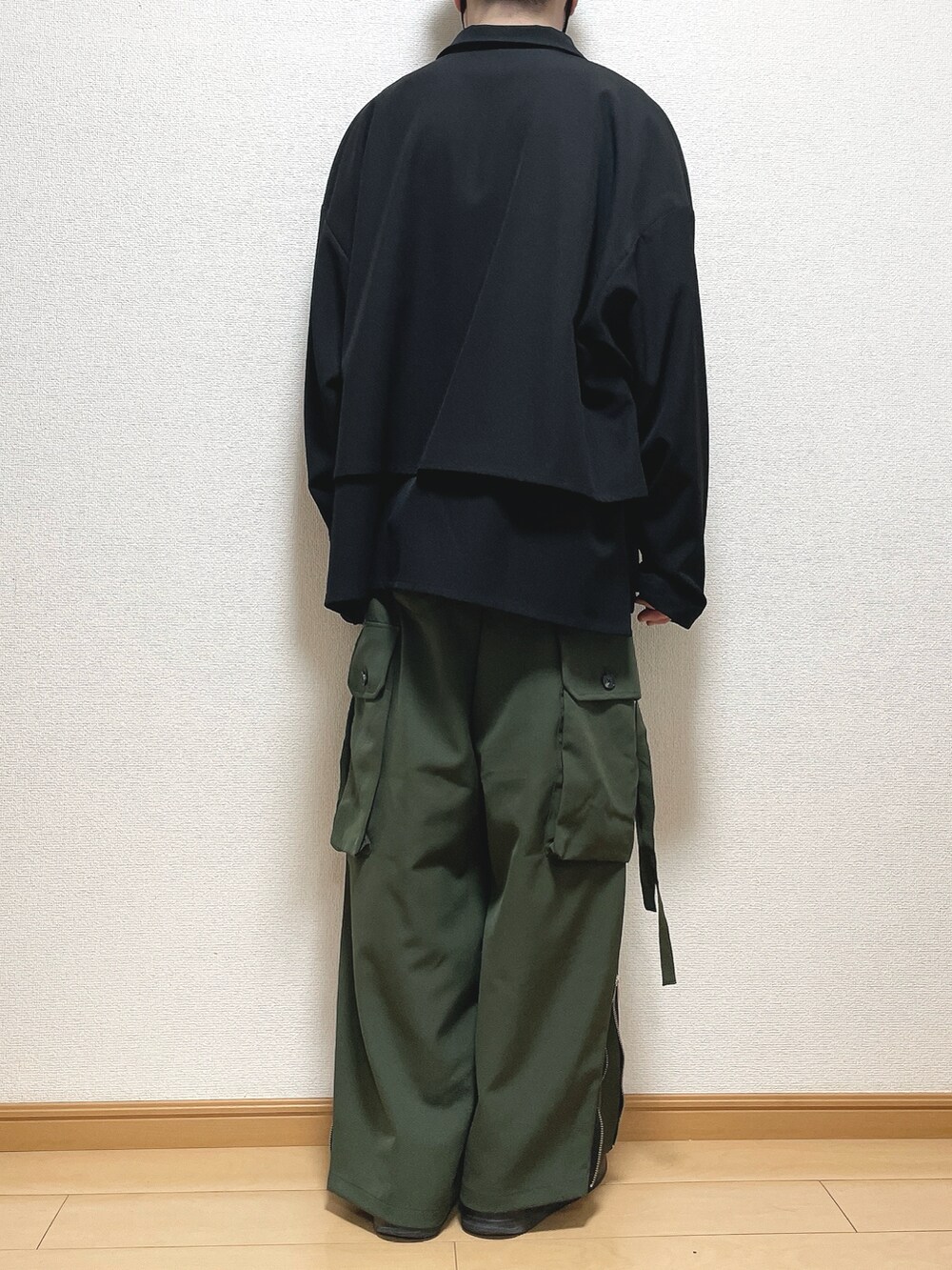 ブラック系のブルゾン、ホワイト系のTシャツ/カットソー、グリーン系のカーゴパンツを着用したメンズの春コーディネートの4枚目の写真