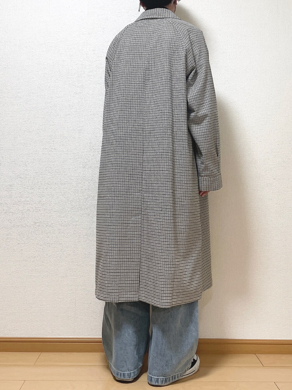 ホワイト系のステンカラーコート、ホワイト系のTシャツ/カットソー、ブルー系のデニムパンツを着用したメンズの春コーディネートの4枚目の写真