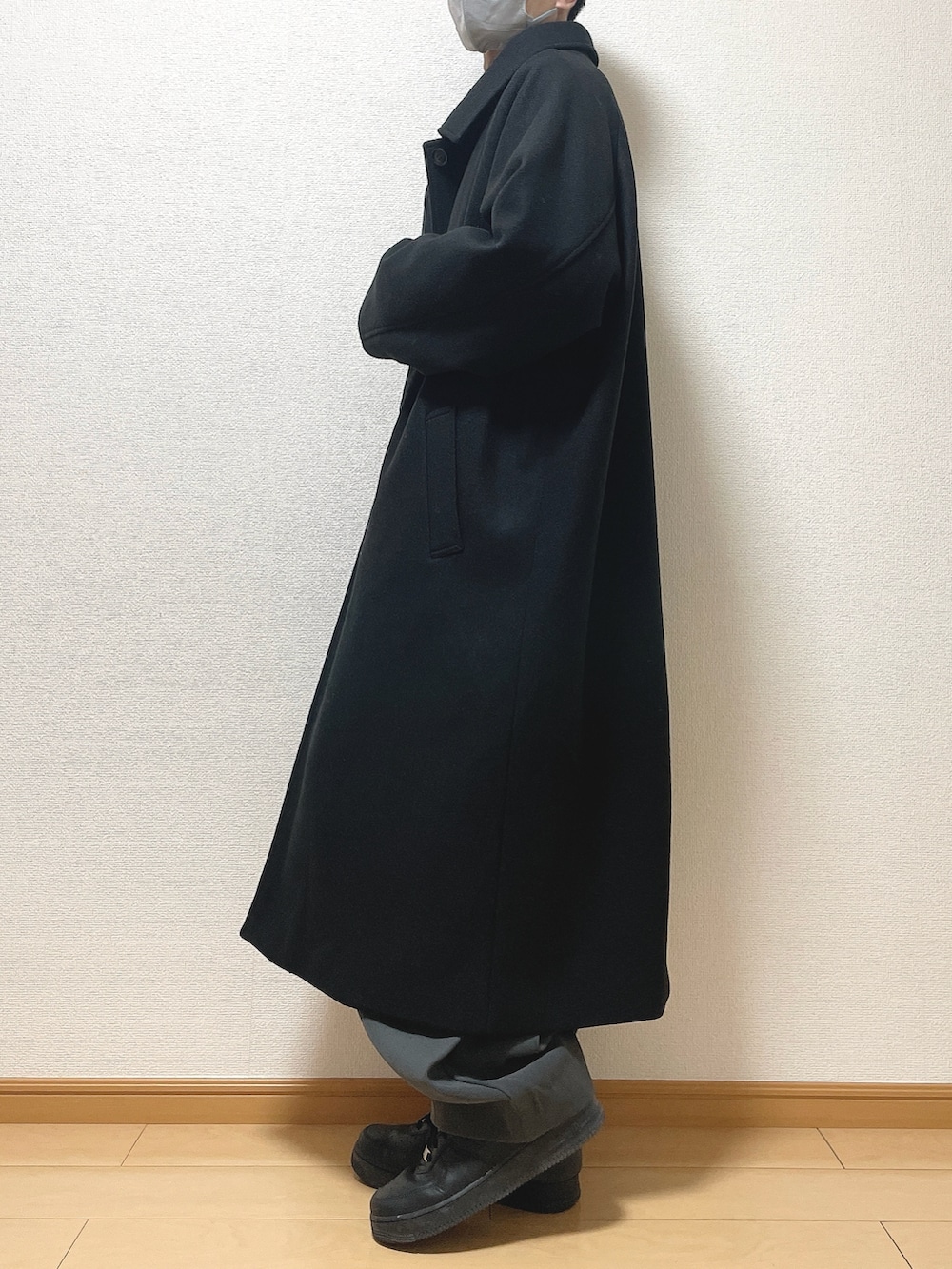 ブラック系のステンカラーコート、ブラウン系のシャツ/ブラウス、ブラック系のTシャツ/カットソーを着用したメンズの冬コーディネートの3枚目の写真