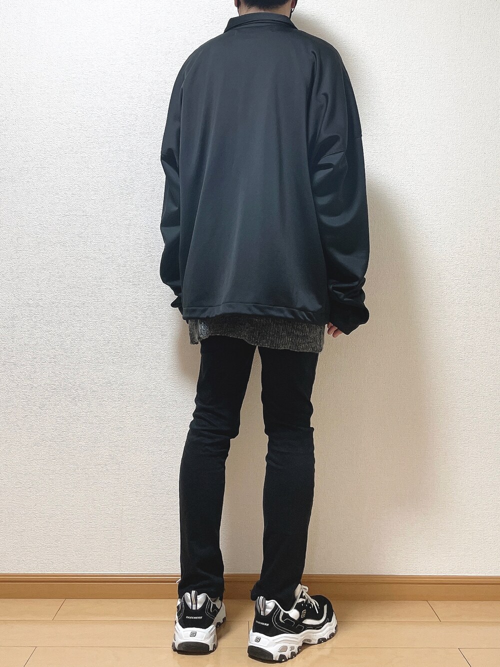 ブラック系のブルゾン、グレー系のニット/セーター、ブラック系のデニムパンツを着用したメンズの秋コーディネートの4枚目の写真