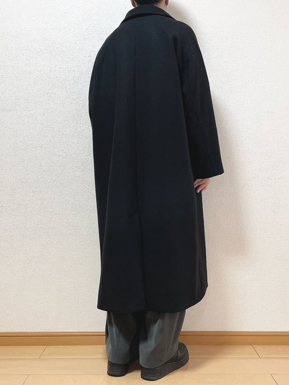 ブラック系のステンカラーコート、ブラック系のスウェット、グレー系のTシャツ/カットソーを着用したメンズの冬コーディネートの4枚目の写真