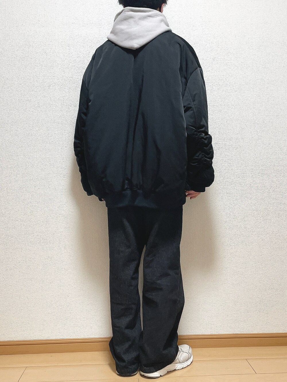 ブラック系のMA-1、グレー系のパーカー、ブラック系のデニムパンツを着用したメンズの冬コーディネートの4枚目の写真