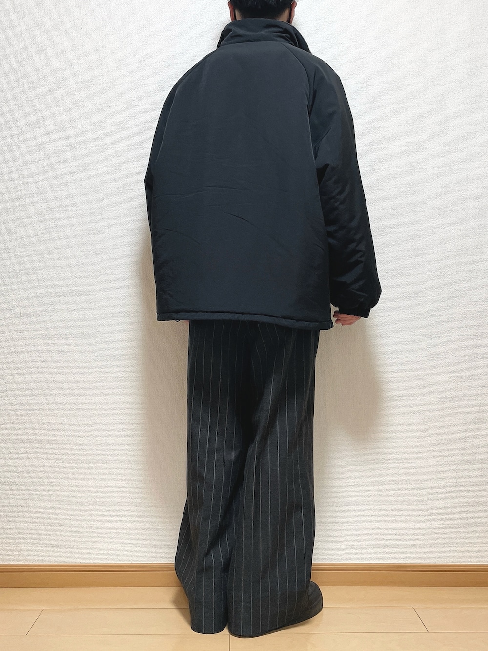 ブラック系のその他アウター、ブラック系のスウェット、ブラック系のパンツを着用したメンズの冬コーディネートの4枚目の写真