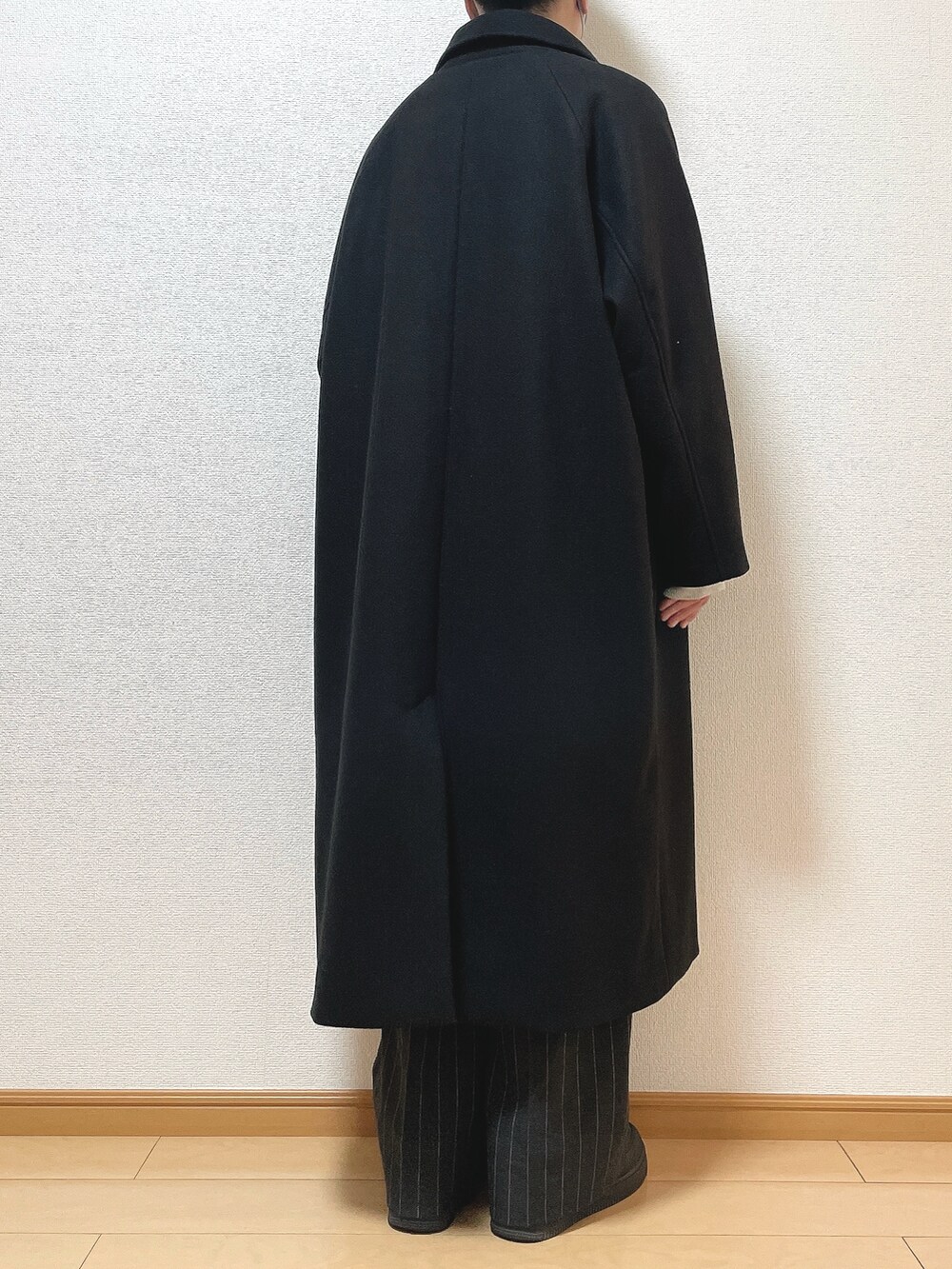 ブラック系のステンカラーコート、グレー系のスウェット、ブラック系のパンツを着用したメンズの冬コーディネートの4枚目の写真