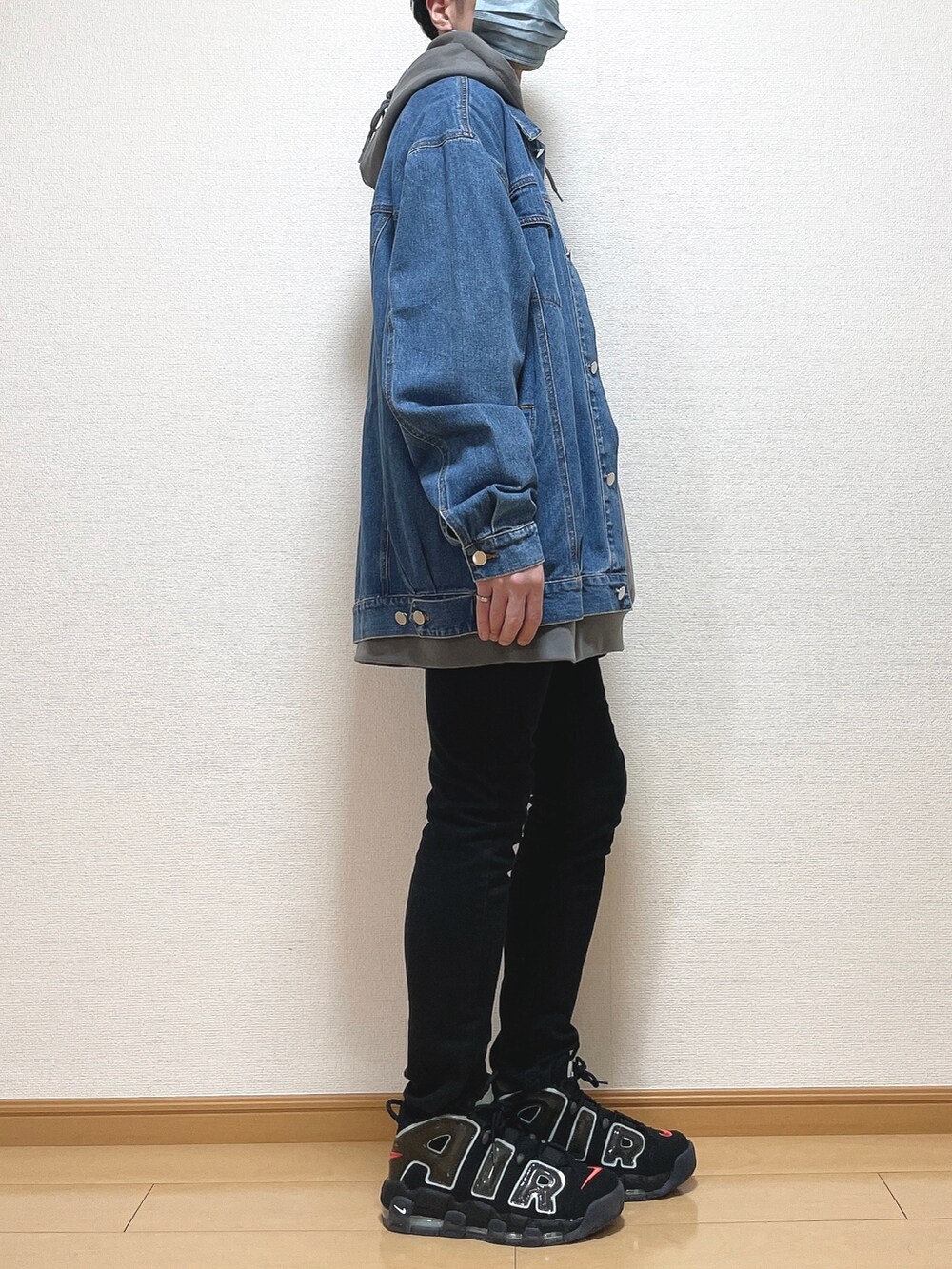 ブルー系のデニムジャケット、グレー系のパーカー、ブラック系のデニムパンツを着用したメンズの春コーディネートの2枚目の写真