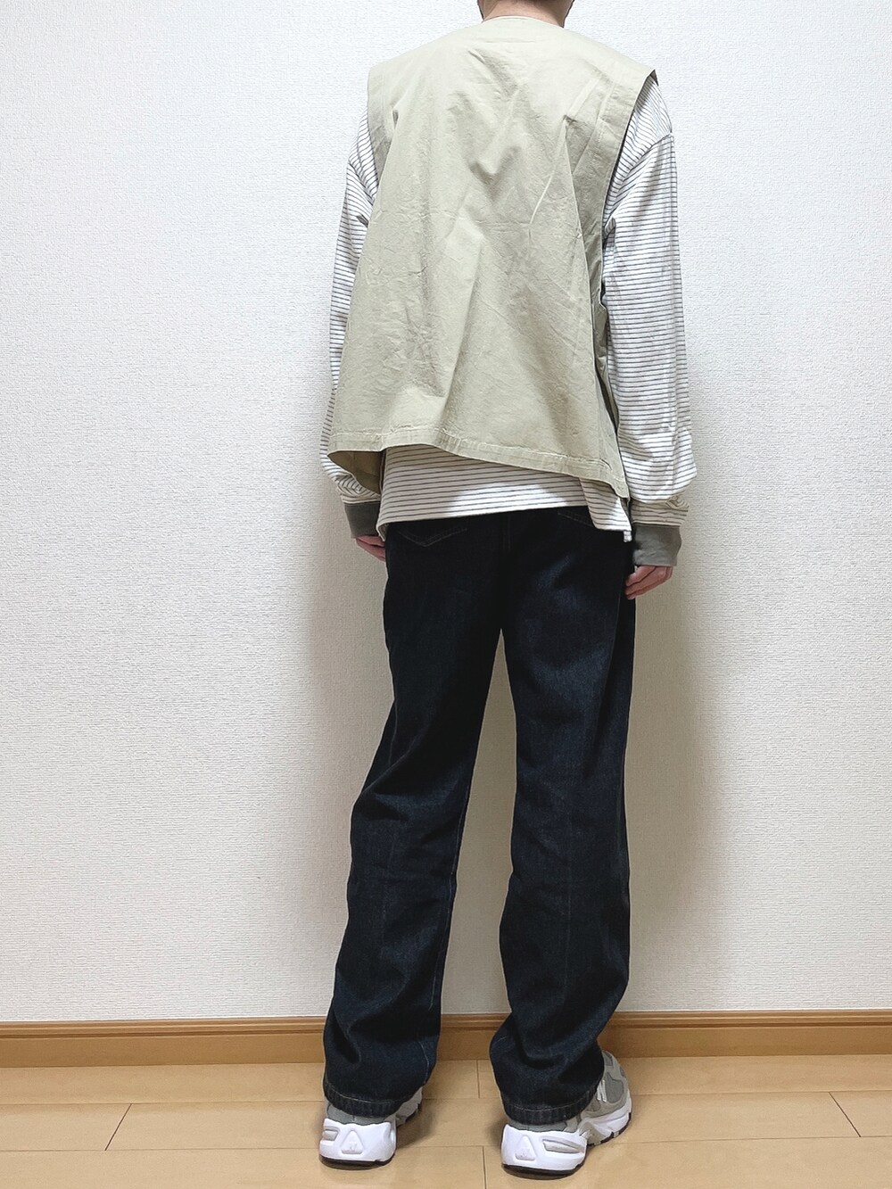 グリーン系のTシャツ/カットソー、ブラック系のデニムパンツ、グレー系のスニーカーを着用したメンズの春コーディネートの4枚目の写真