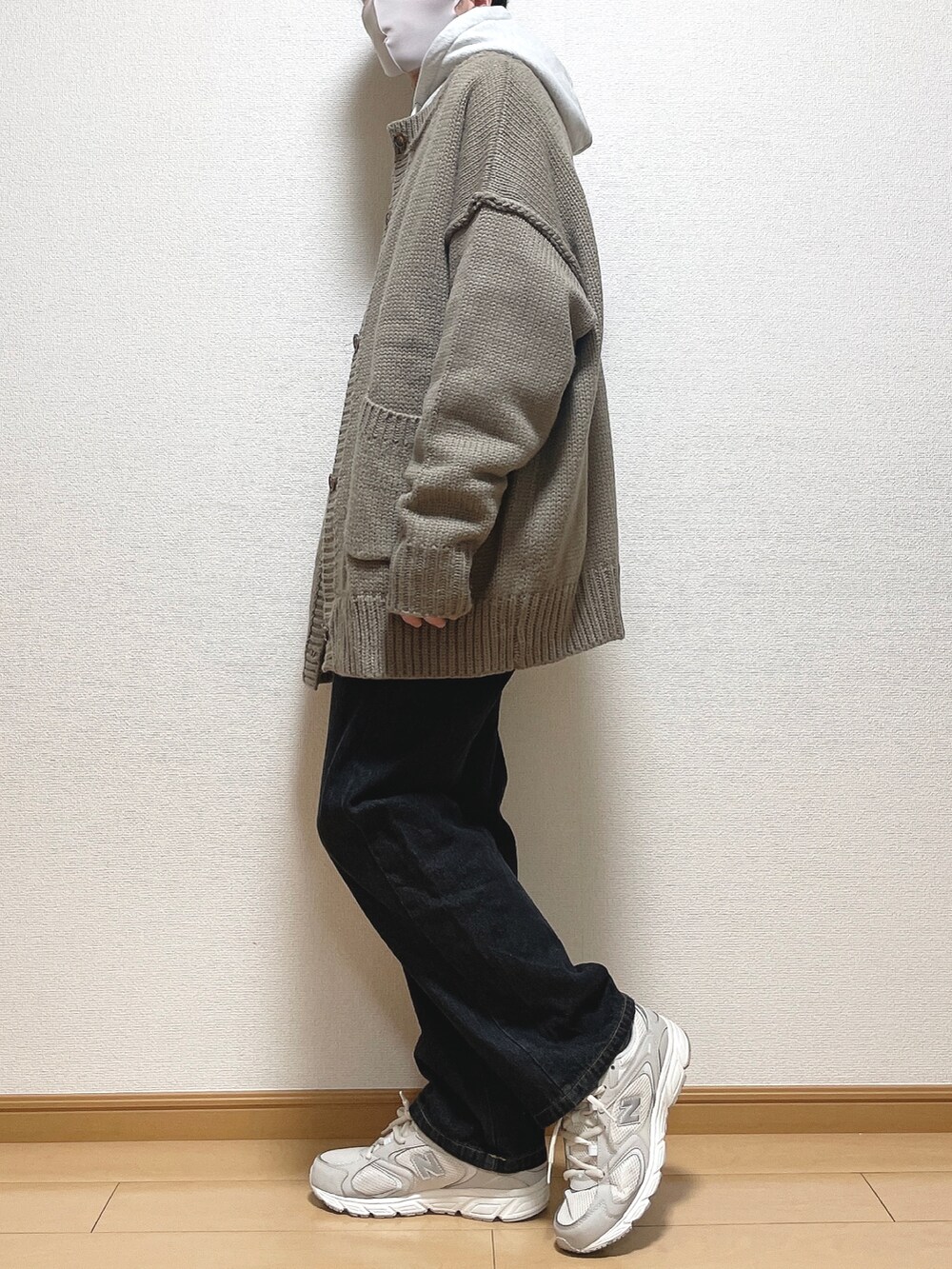ベージュ系のカーディガン/ボレロ、グレー系のパーカー、ブラック系のデニムパンツを着用したメンズの冬コーディネートの3枚目の写真