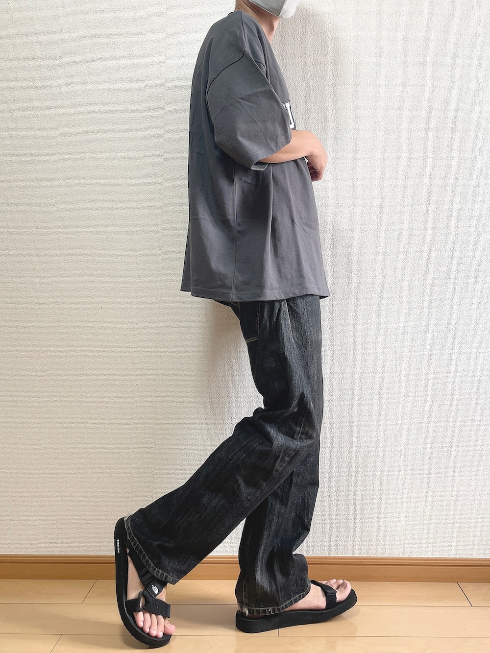 グレー系のTシャツ/カットソー、ブラック系のデニムパンツ、ブラック系のサンダルを着用したメンズの夏コーディネートの3枚目の写真