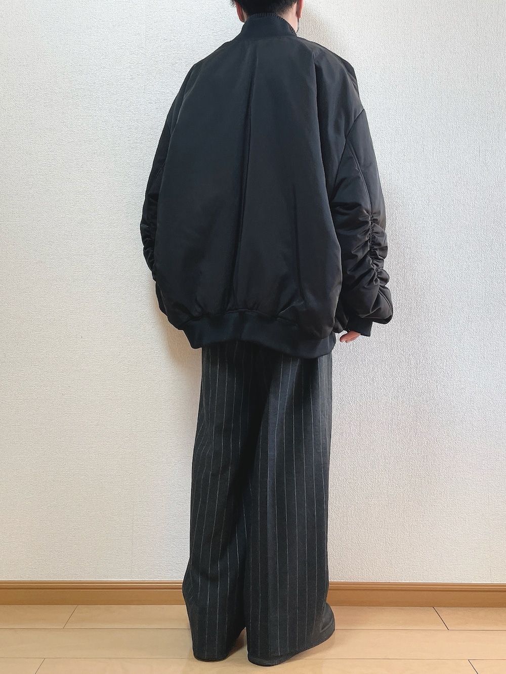 ブラック系のMA-1、グレー系のニット/セーター、ブラック系のパンツを着用したメンズの冬コーディネートの4枚目の写真
