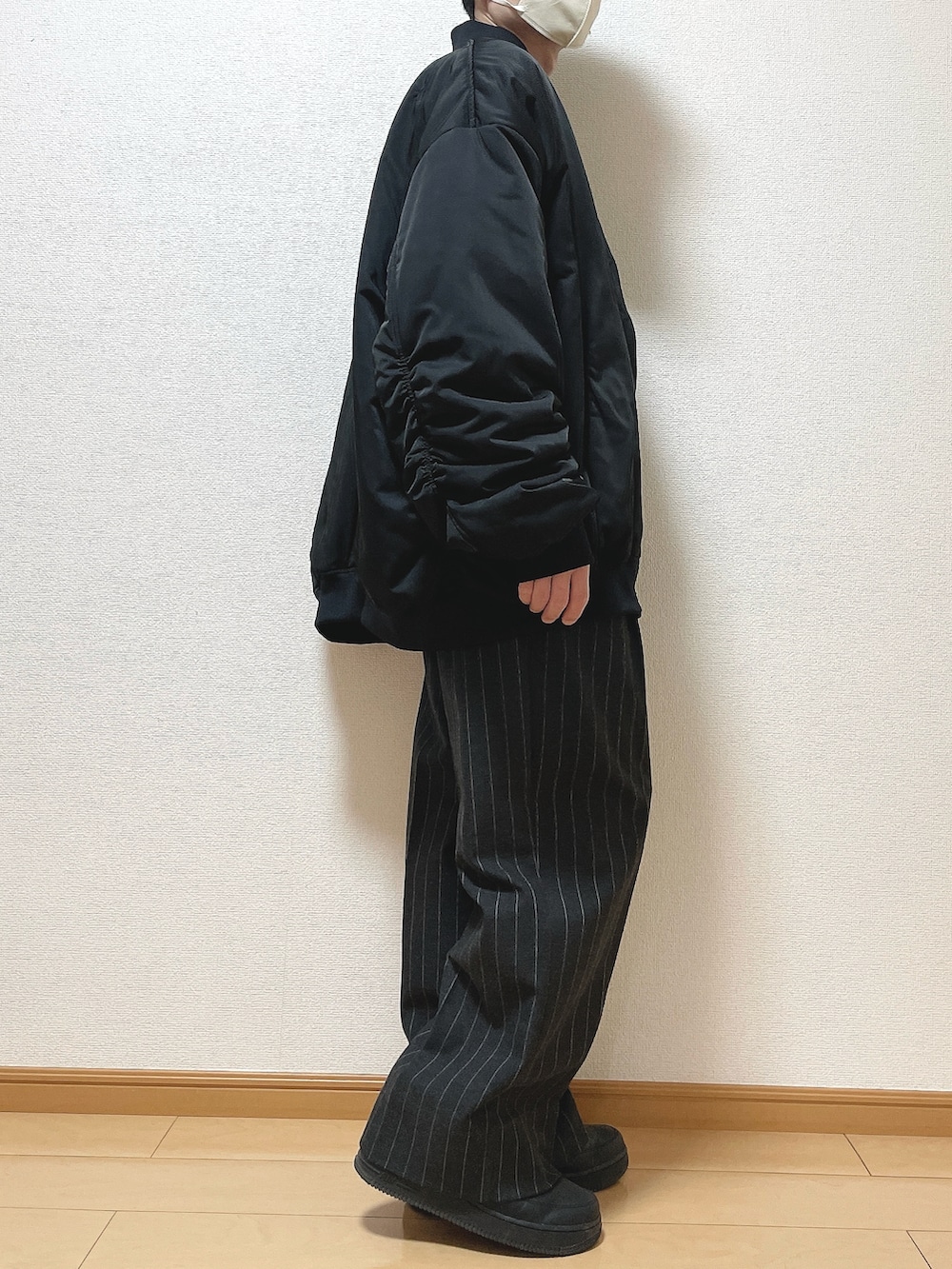 ブラック系のMA-1、ブラウン系のニット/セーター、ブラック系のパンツを着用したメンズの冬コーディネートの2枚目の写真