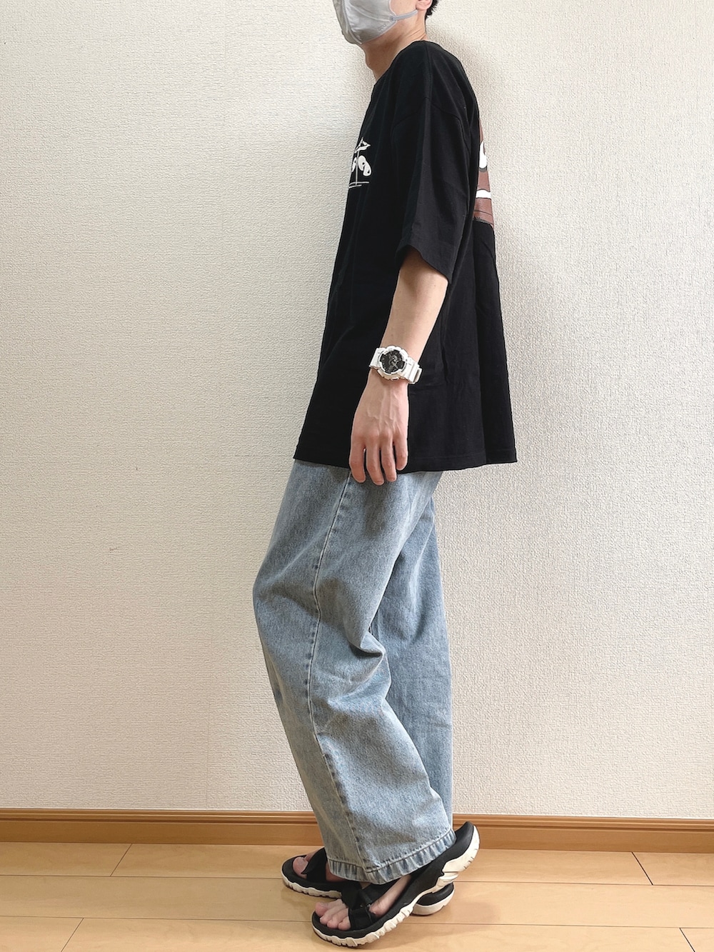 ブラック系のTシャツ/カットソー、ブルー系のデニムパンツ、ブラック系のサンダルを着用したメンズの夏コーディネートの4枚目の写真